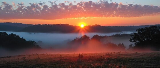 Fototapeta premium Serene Sunrise: Misty Morning with Low-Hanging Clouds in Rural Landscape