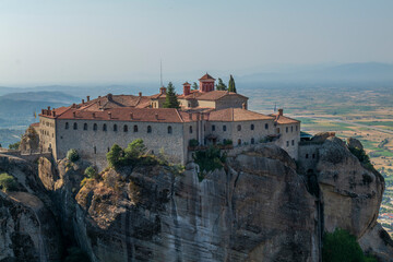 Obraz premium Monasteries located on unique rock formations in the Meteora region of Greece are illuminated by the sunrise light.
