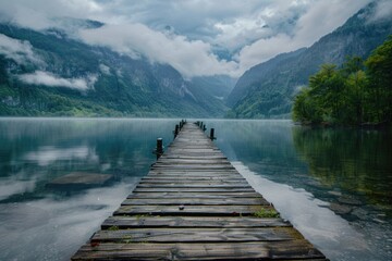 Fototapeta premium A long wooden dock stretches out into the lake with calm waters and surrounding vegetation