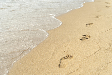 Traces on the wet sandy seashore with waves