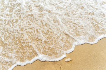 Waves on the golden sandy seashore