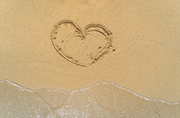 Traces on the wet sandy seashore with waves