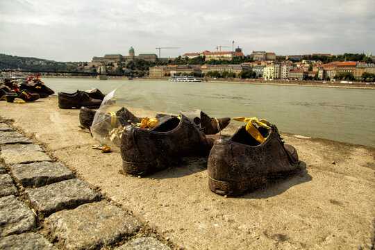 Iron shoes sit on a stone riverbank overlooking the Danube and cityscape. Such powerful monuments preserve painful memories and encourage deep reflection on universal human rights and world peace.