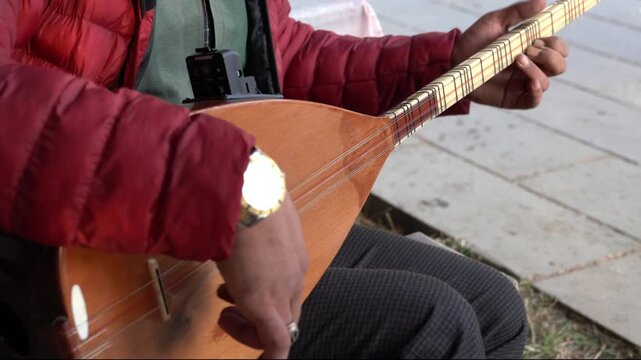 Man playing Turkish musical instrument baglama which is the most commonly used string folk instrument in Turkey