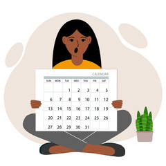 A woman sits cross-legged and holds a large calendar glider in his hands. Concept of planning, make plans, schedule, event.