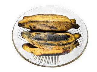 Boiled bananas on a plate over a white background. Boiled Kepok bananas isolated on a white background. Boiled bananas or Pisang Rebus is one of popular the traditional foods in Indonesia.