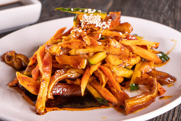 Spicy Pig Ear Salad Dish on wood table. Chinese food. wooden sticks, soy sauce