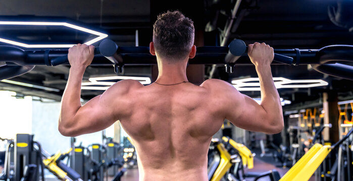 Back view of a man doing push-ups in the gym. Sports lifestyle.