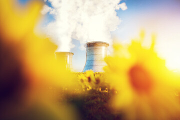 Sunflowers and nuclear cooling towers under bright sky
