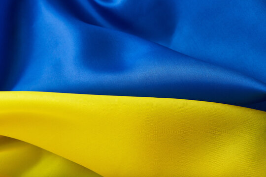 Ukrainian national flag. Blue and yellow colors fabric. Close up shot, selective focus, background, top shot, horizontal orientation