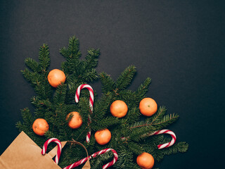 Christmas composition. Candy cane with fir branches and mandarins in a craft bag. Top view. Christmas, winter, new year concept.