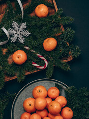 Christmas card with tangerines. Plate with tangerines with Christmas decorations