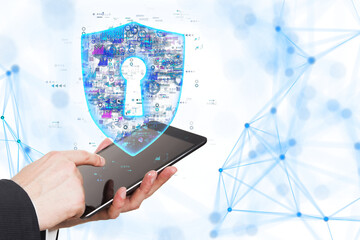 Hands holding a tablet with a holographic shield displaying a keyhole, set against a white background. Concept of digital security and data protection