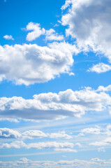 Blue sky landscape with white evening sky clouds lit by sunny, blue sky background