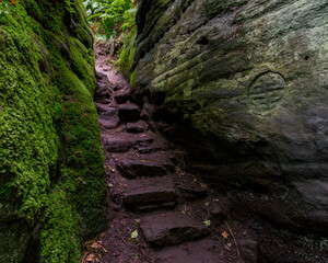 The winding set of steps carved into the rocks with many etchings such as Celtic crosses, human...