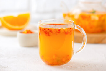Hot sea buckthorn tea with orange, ginger and cinnamon in glass cups. Herbal vitamin c tea.