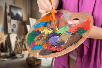Artist Painting with Palette and Brush in Studio