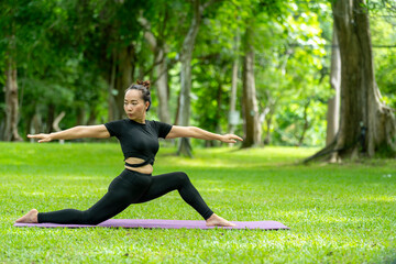 A woman is doing yoga in a park