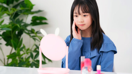 鏡を見ながらメイクをする女の子　キッズコスメ