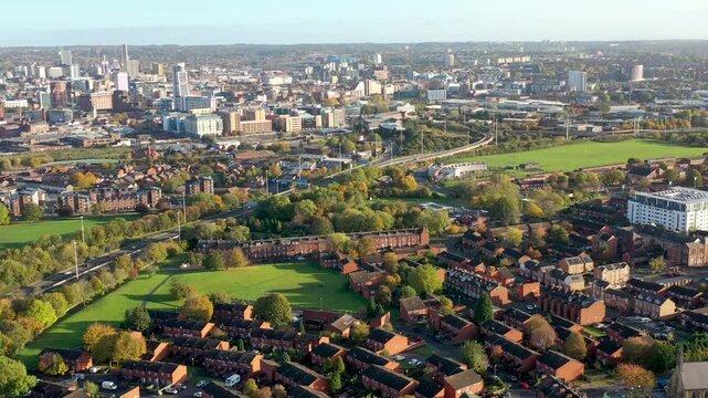Aerial footage of the motorway in the UK known as the M62 showing traffic on the road on a beautiful sunny day in the spring time with the Leeds city centre in the background.