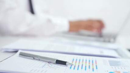 Close-up of pen with employee sitting and working