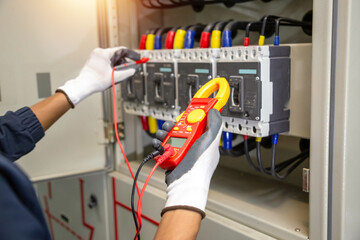 Checking the electrical system, an electrician is using an electric meter to check the electrical...