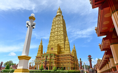 Amazing scene of a great golden pagoda with cloudy blue sky at buddhist temple. Wat Mahathat Wachiramongkhon or Wat Bang Thong, Krabi Province, Thailand.