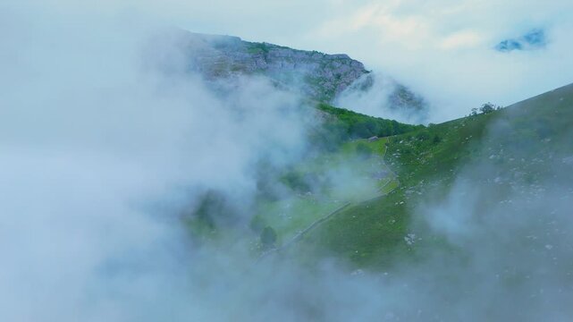 Fog in the spring landscape of pastures and Pasiegas cabins in the Natural Park of the Collados del As&oacute;n. Aerial view from a drone. Hills of Ason Natural Park. Soba Valley, Cantabria, Spain, Europe
