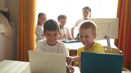 Fototapeta premium group of children study at home via laptops. business concept of modern training and development. little kids are lifestyle educated through the computer. two boys with laptops in the foreground