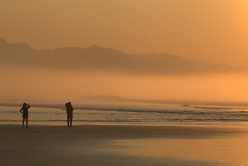 Fototapeta premium Early in the morning on the beach seeing sunrise, Itaguare beach, Bertioga, Brazil