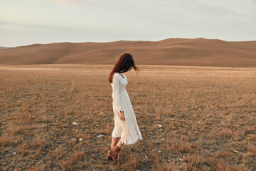 Tranquil sunset beauty in white dress standing alone in open field at dusk