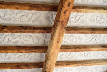 Vigas de madera en techo con decoración de dragones