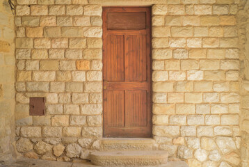 Puerta de madera en fachada de bloques de piedra en edifiicio medieval