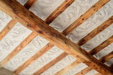 Vigas de madera en techo con decoración de dragones