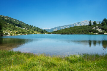 Naklejka premium Pirin Mountains, August photo of Gorno Vasilashko Lake under clear blue sky.