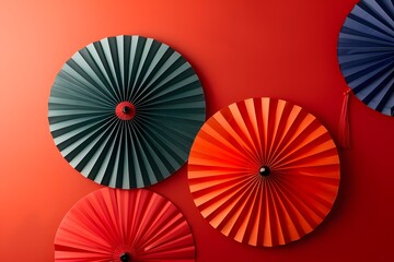 Vibrant Paper Fans Against a Bold Red Wall