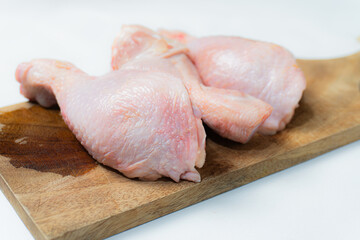 Fresh Raw chicken Drumsticks on cutting board isolated on a white background.