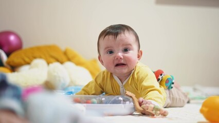 baby 6 months playing with a toy. kid in kindergarten playing on the floor many toys indoors. happy family baby dream concept. little infant baby play in lifestyle kindergarten. happy childhood
