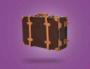 Vintage suitcase in air on purple background