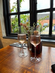 Two glasses of pink prosecco on a pub table in the UK