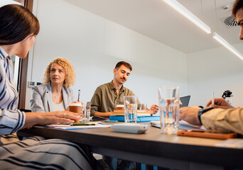Portrait of an business man sitting in a meeting room and talking with colleagues.