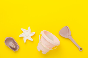 Cute toys for playing with sand on color background, top view
