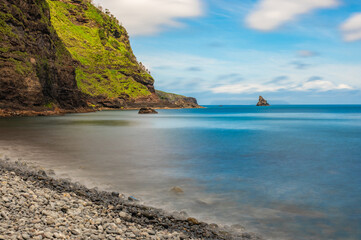 Baía de Alagoa on the island of Ilha das Flores, Azores, Portugal. Atlantic ocean coastline. Stones, rocks and water in long exposure. Nature photography in motion.