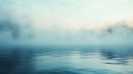 Naklejka premium Serene view of a misty landscape over calm water at dawn.