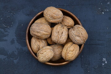 broken walnuts and nutcracker on black background