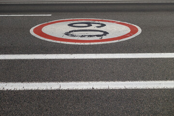 Sixty speed limit sign on asphalt road.