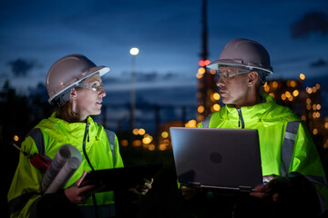 Engineers wear uniform and helmet stand in holding tablet computer , survey inspection work plant...