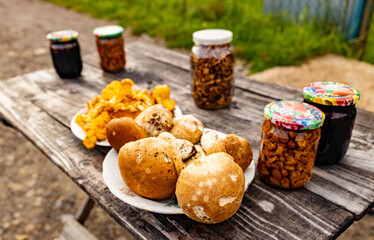 Porcini mushrooms and chanterelles on a table for sale at a local organic market.