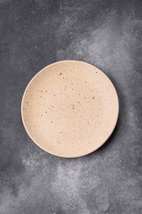 Empty ceramic plate on a dark textured background