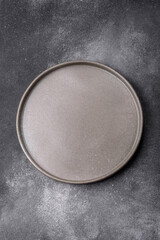 Empty ceramic plate on a dark textured background